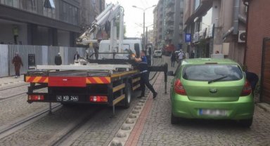 Tramvay yoluna park edilen araçlar çekiliyor